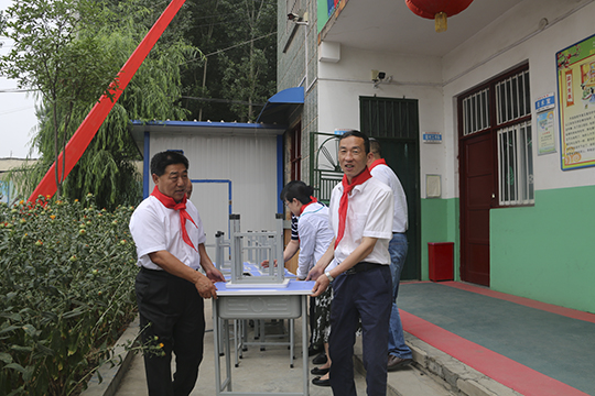 乐竞(中国)领导与学生一起将桌椅搬进教室